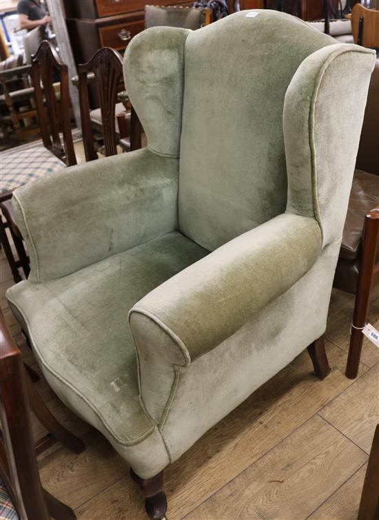 A green upholstered wing armchair